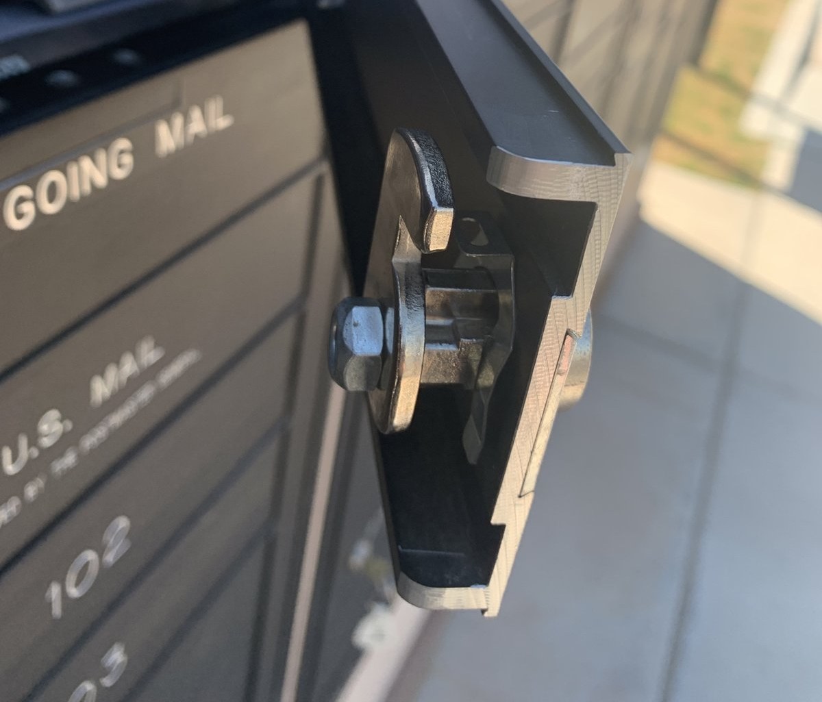 Back of a cluster mailbox door showing the new cam lock and tailpiece