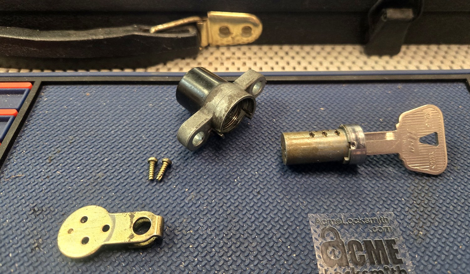 Motorcycle lock cylinder disassembled on the bench with a cut key